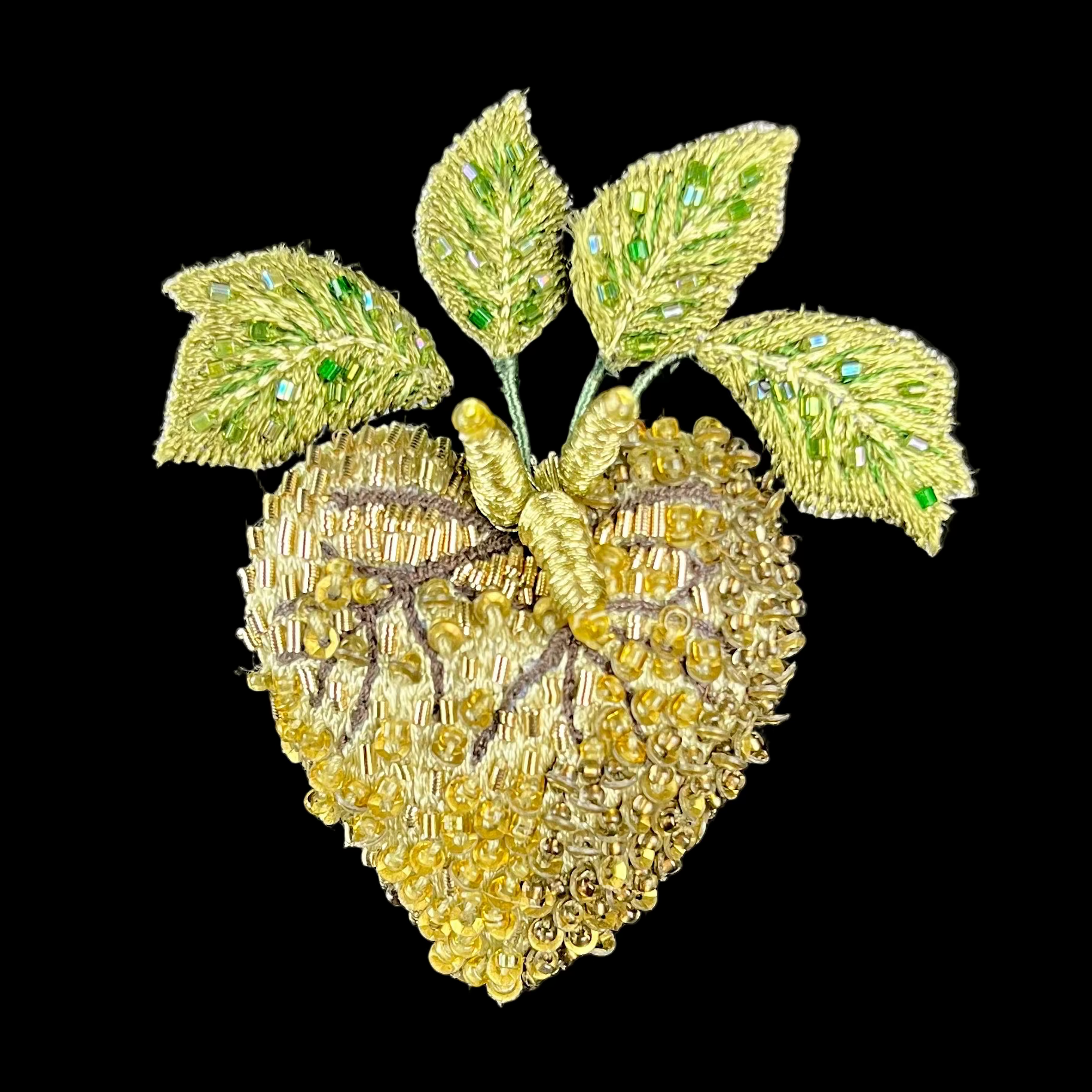 Heart-shaped brooch with leaf details on a black background