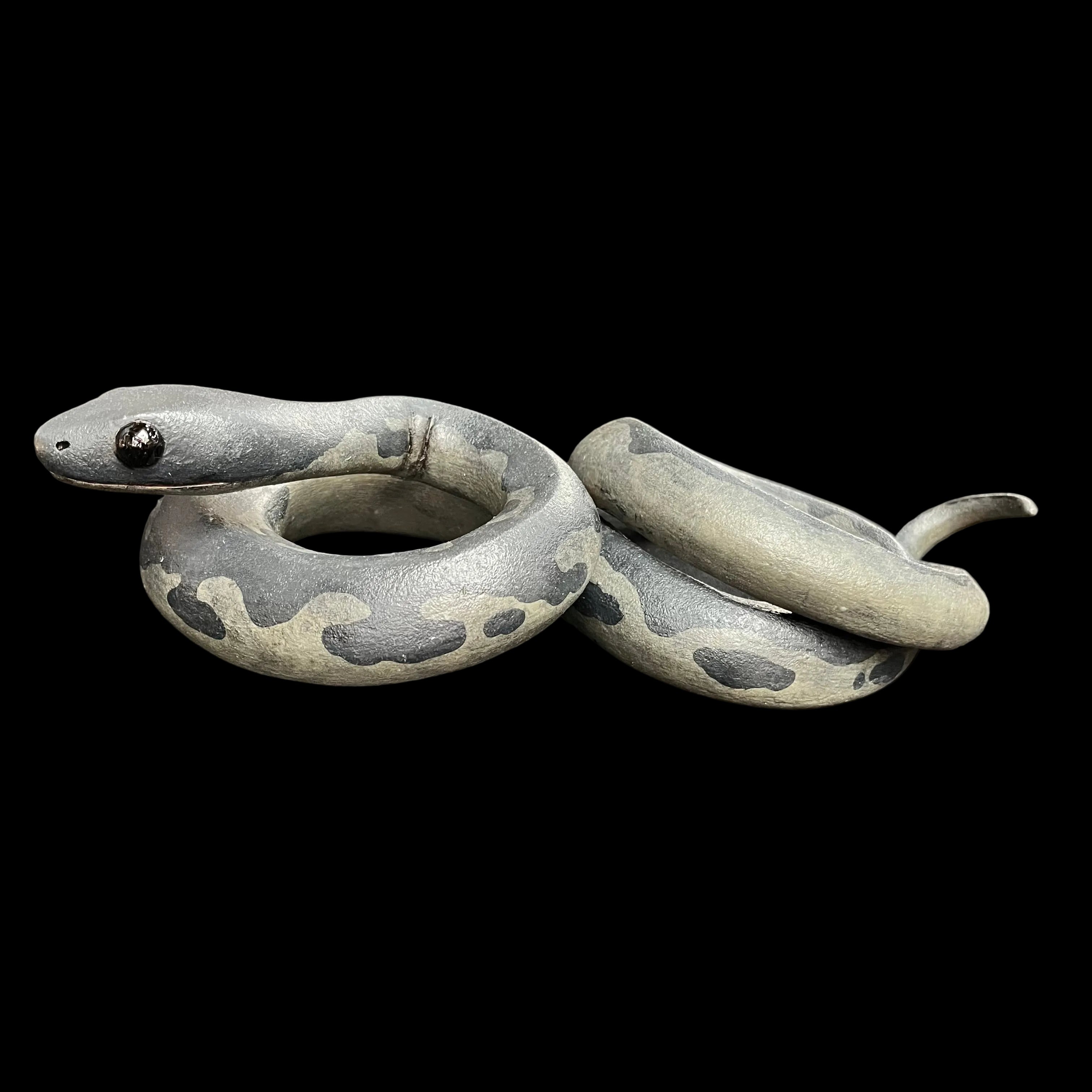 Gray snake model on a dark surface with blurred background