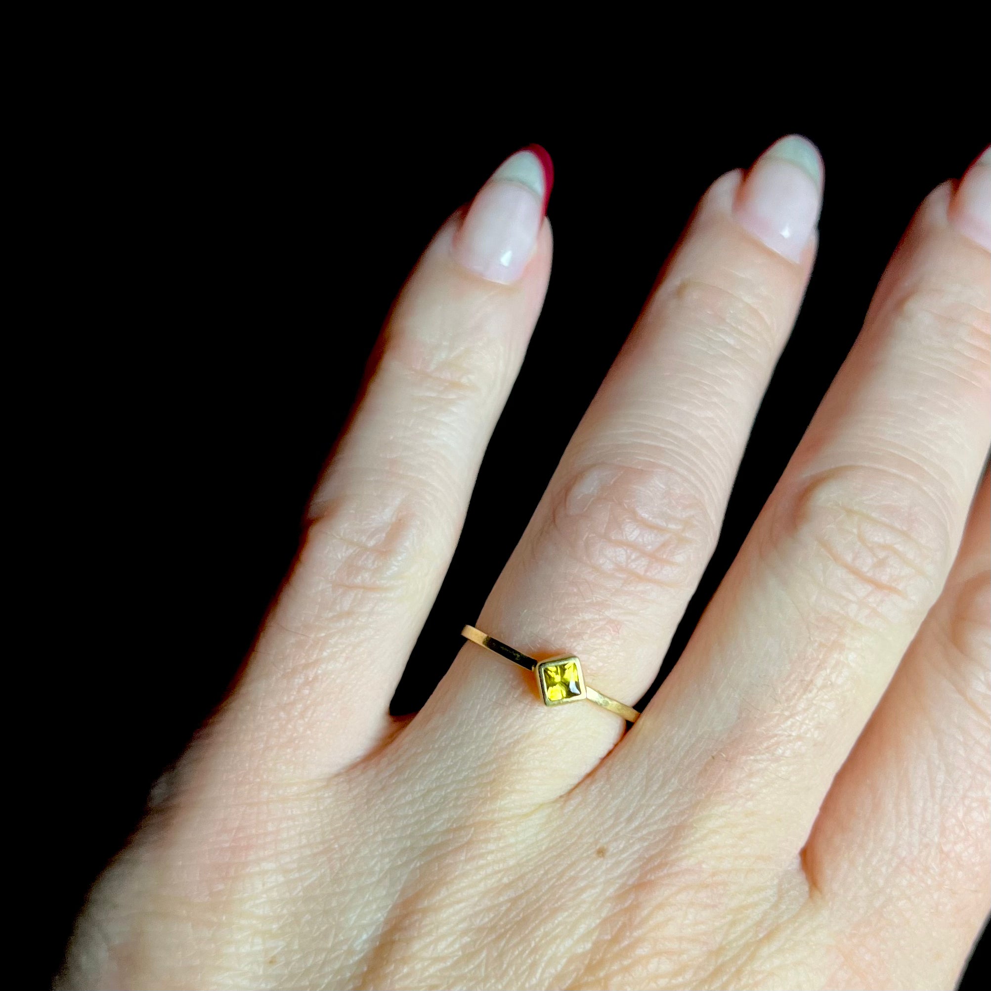 Yellow Stone Gold Ring shown on hand with back background
