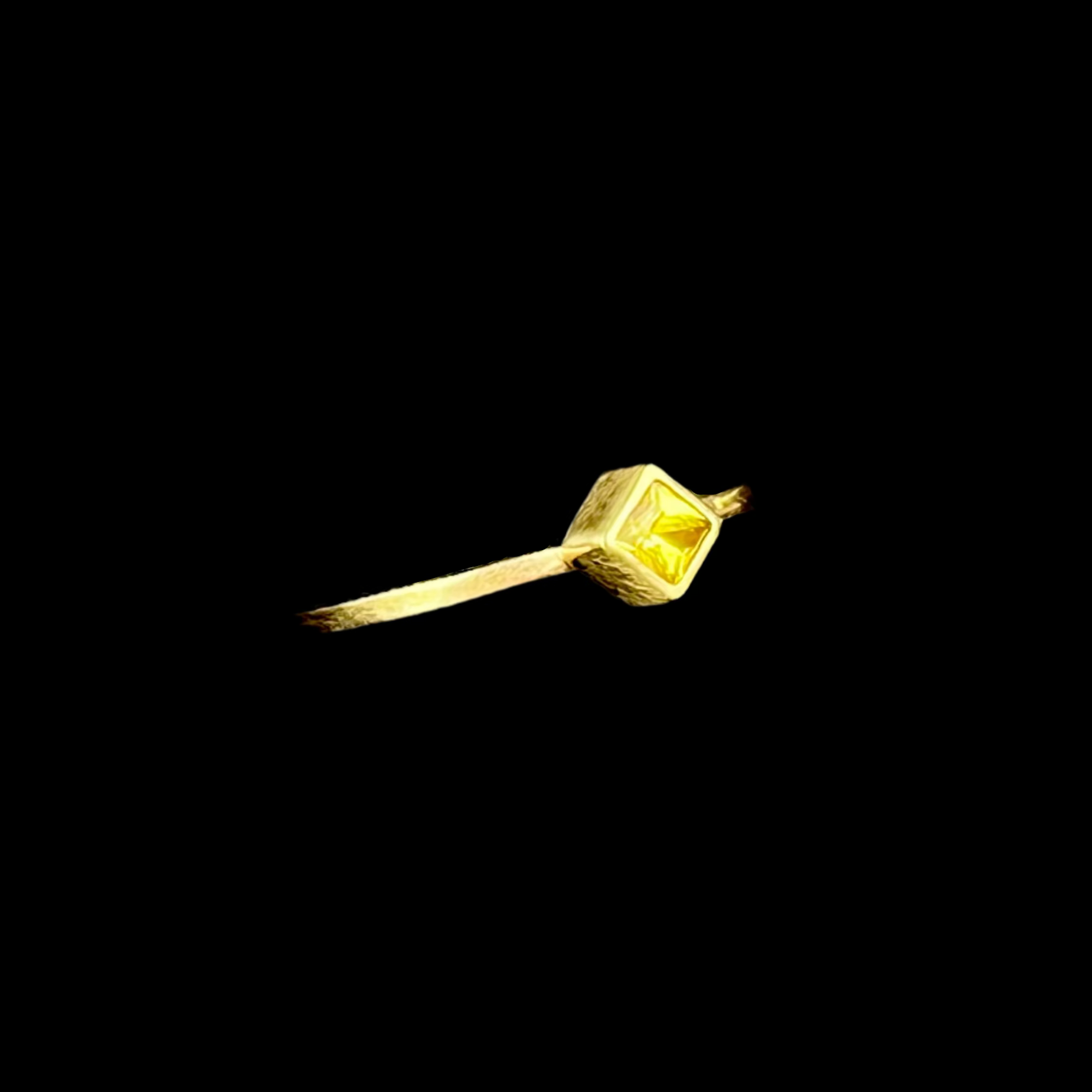 Gold ring with a diamond on a black background