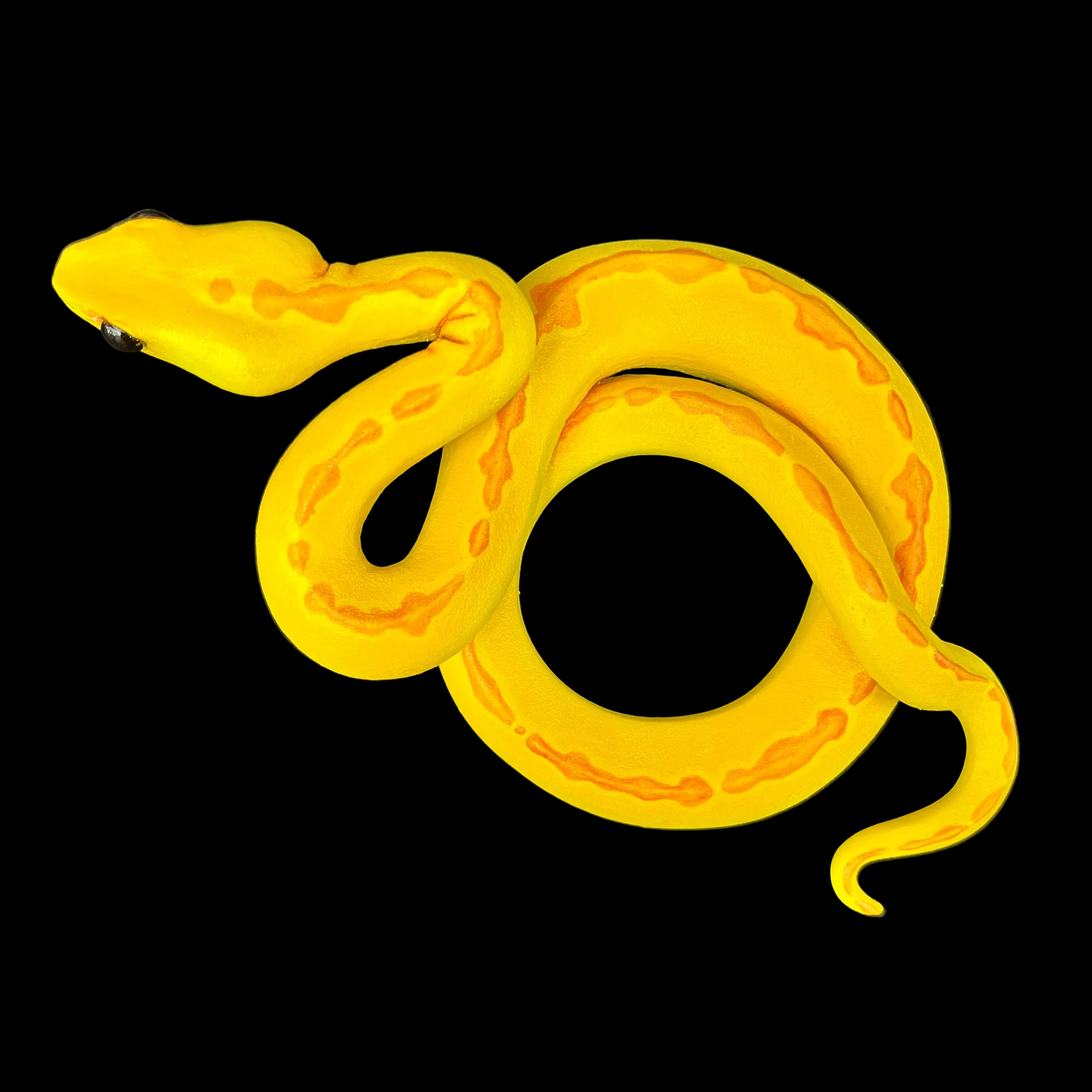 Yellow rubber snake sculpture on a black background