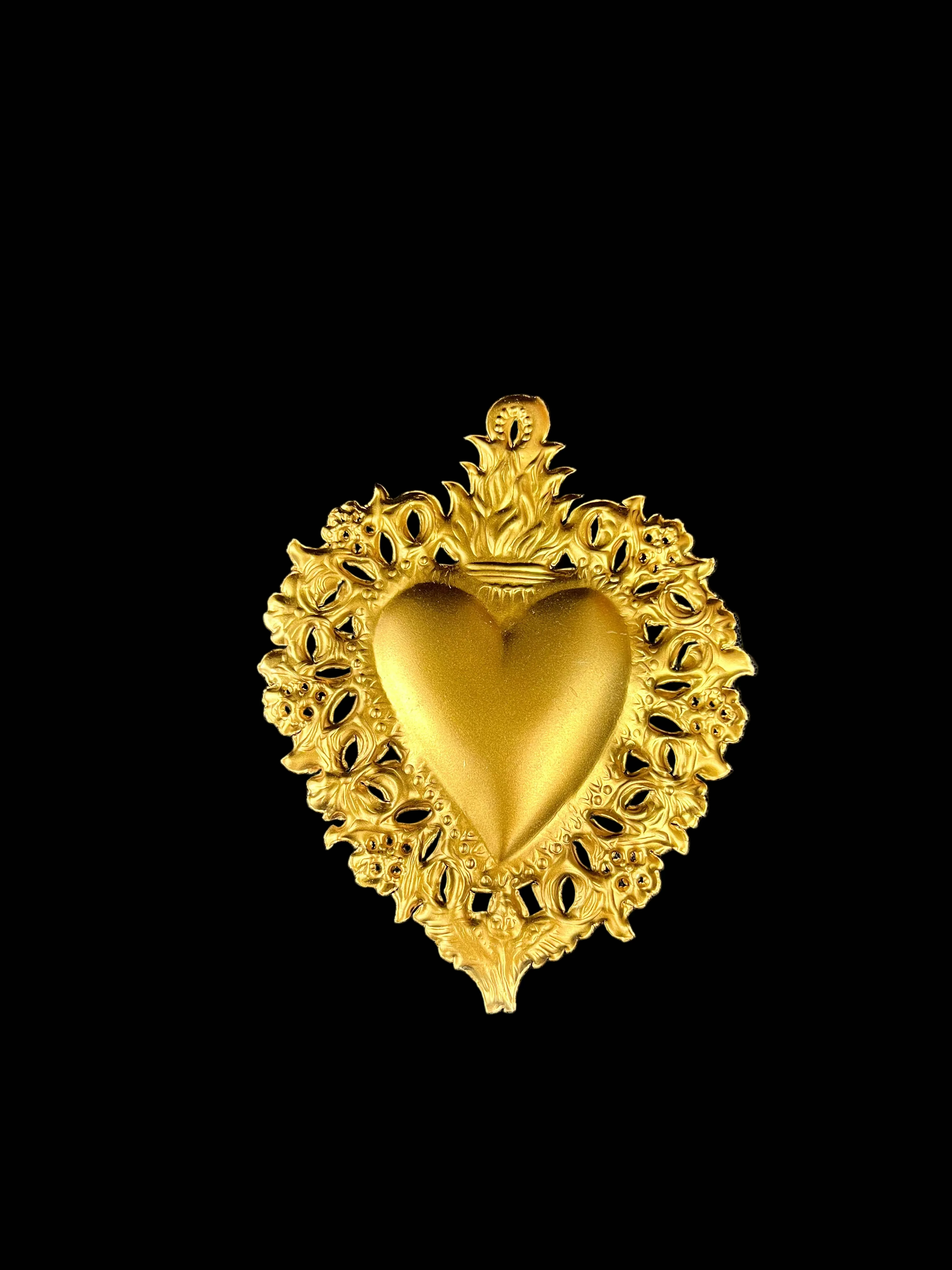 Gold heart-shaped decorative item on a gray fabric background