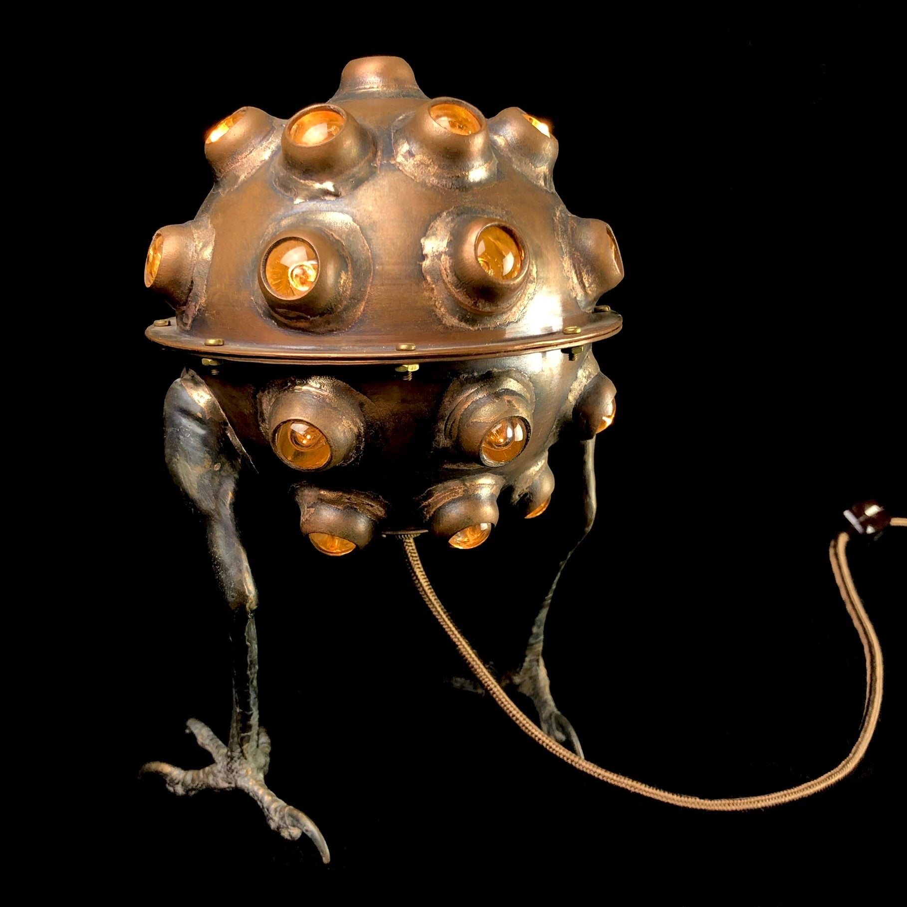 Copper Lamp with glass accents and hawk feet on black background