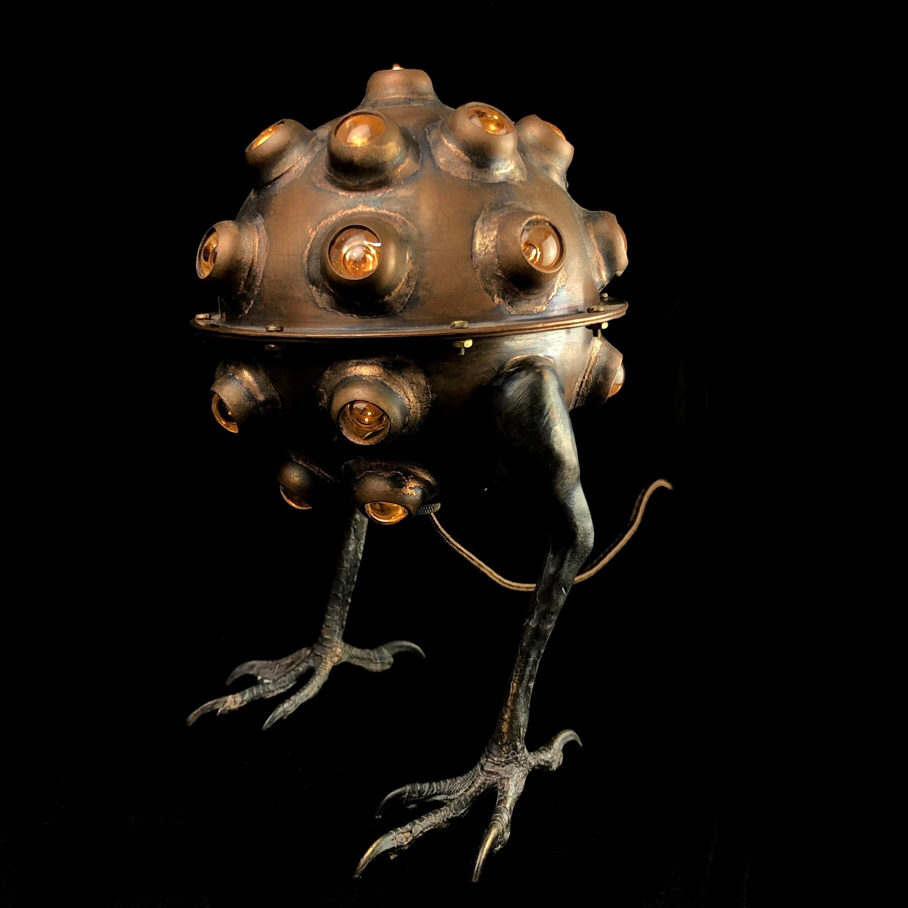 Copper Lamp with glass accents and hawk feet on black background