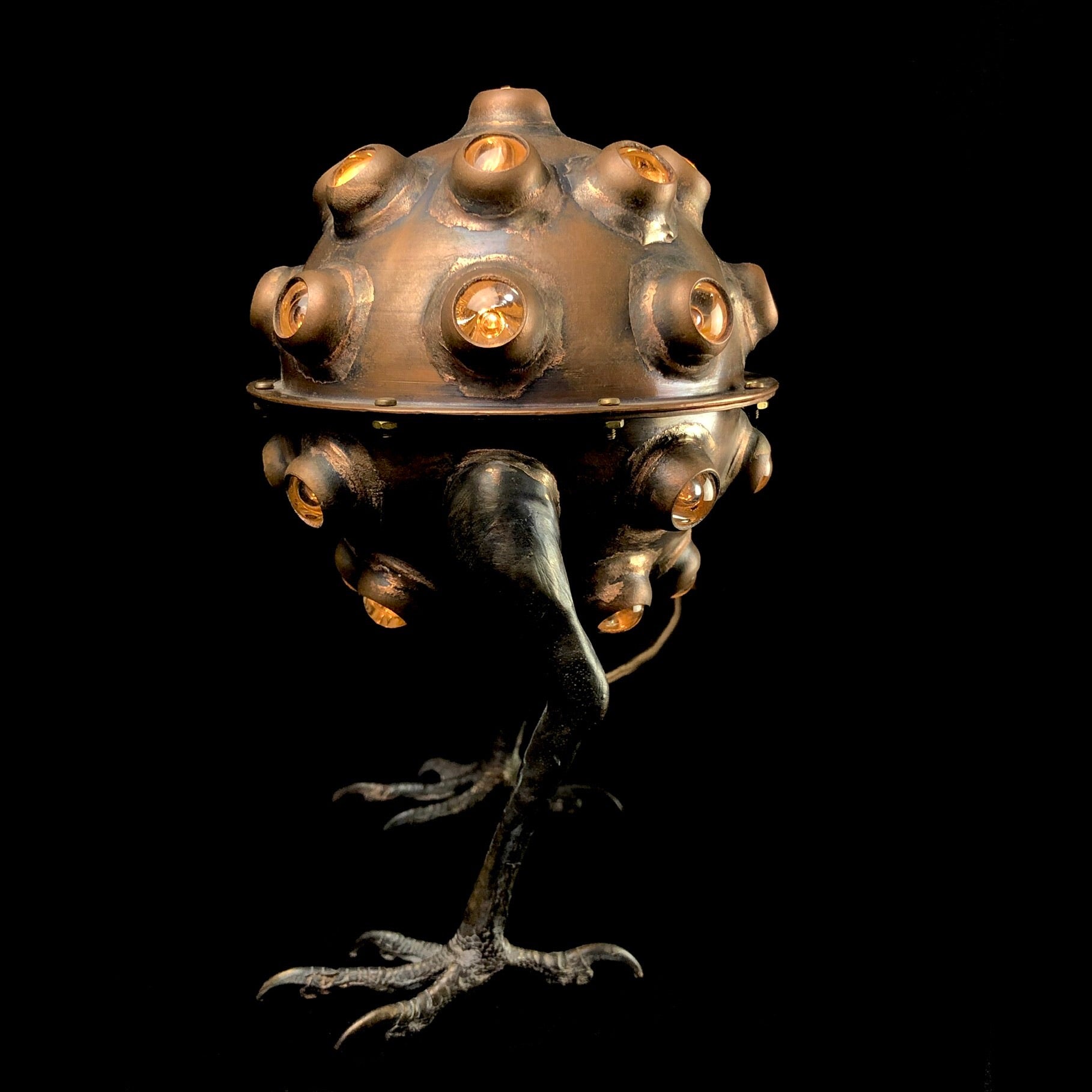 Copper Lamp with glass accents and hawk feet on black background