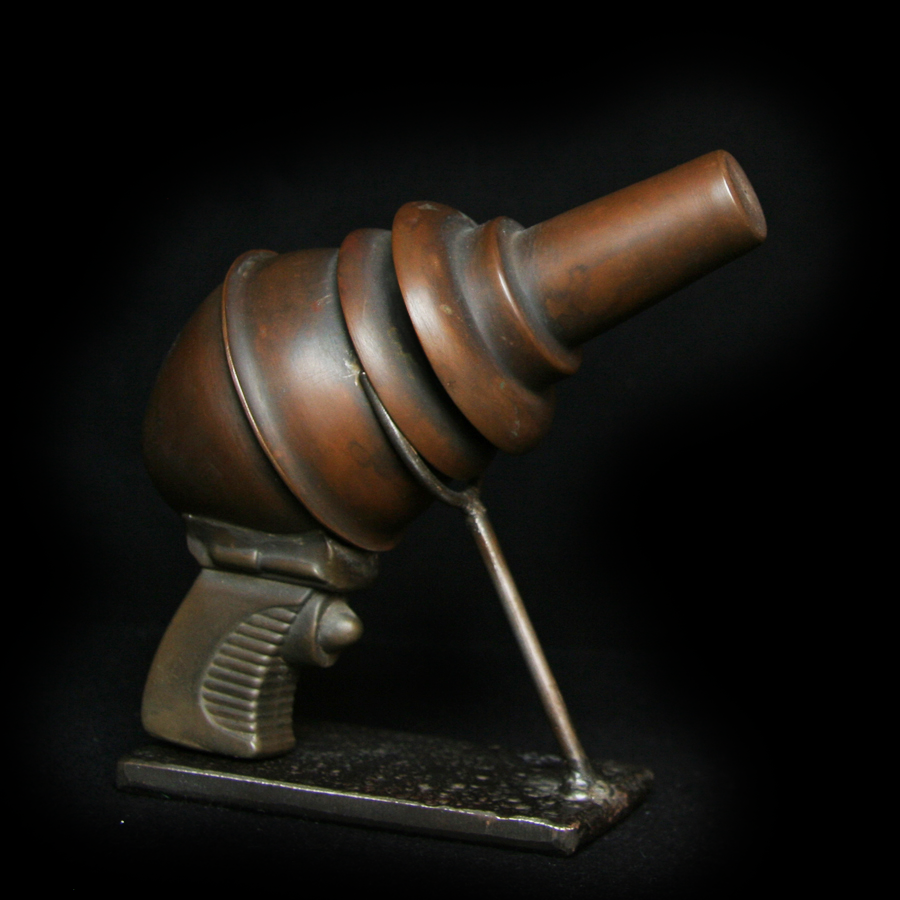 Angled view of copper Ray Gun art object on stand