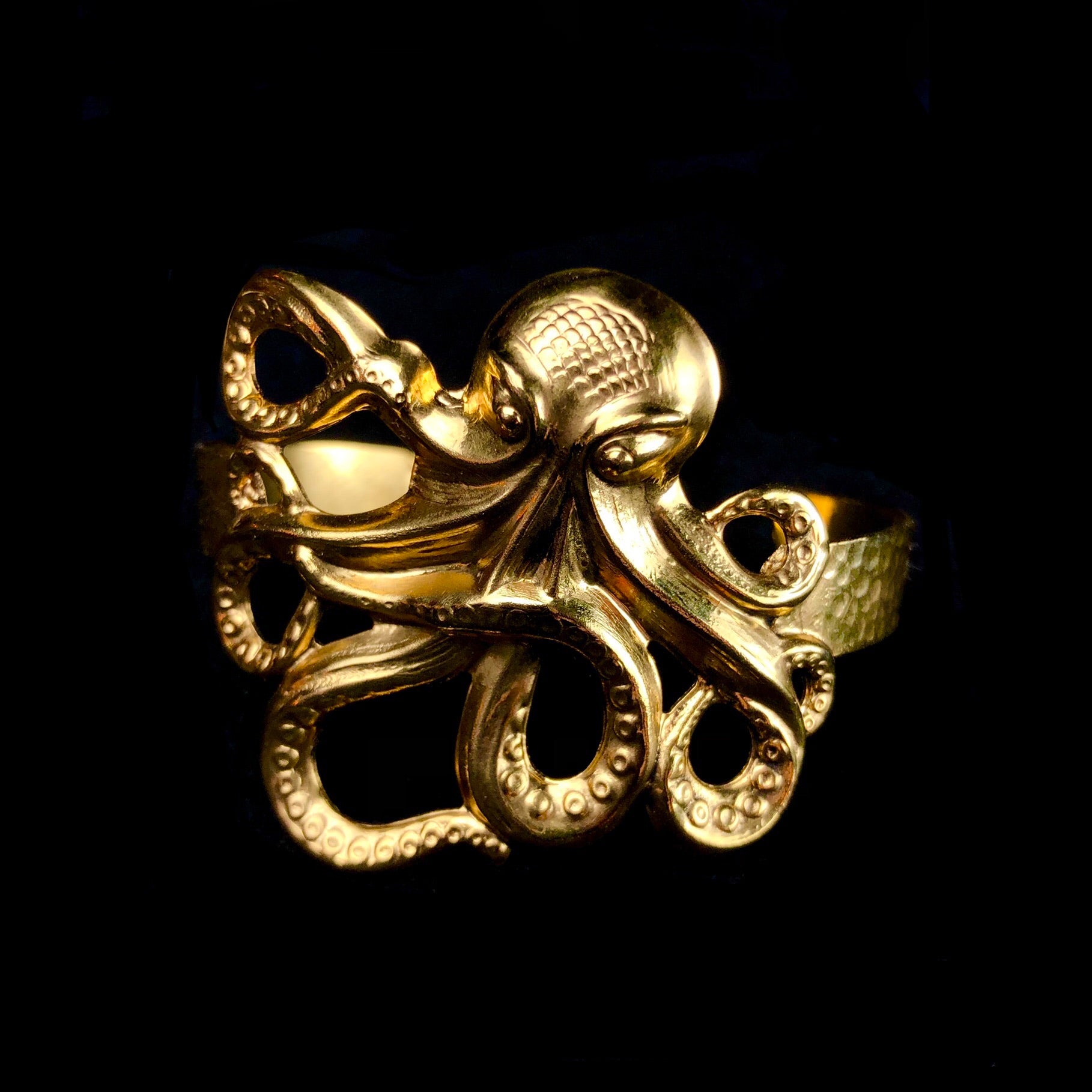 Stamped and cutout gold octopus with tentacles outstretched