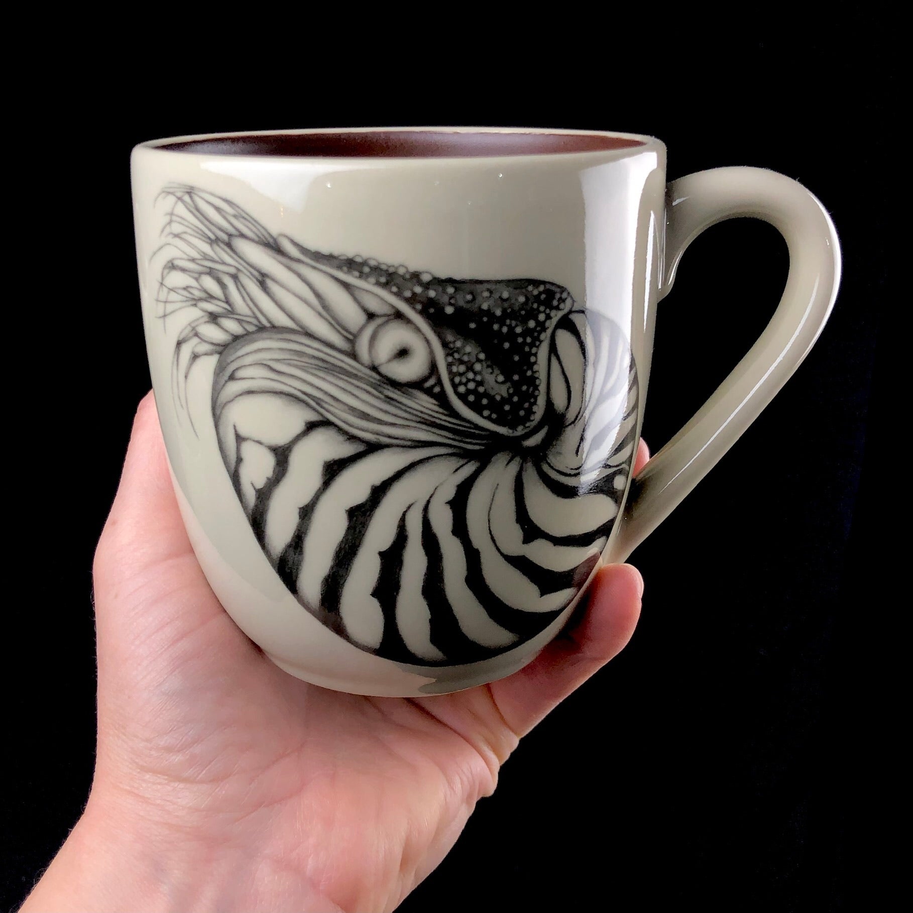 Nautilus Mug shown in hand for size reference