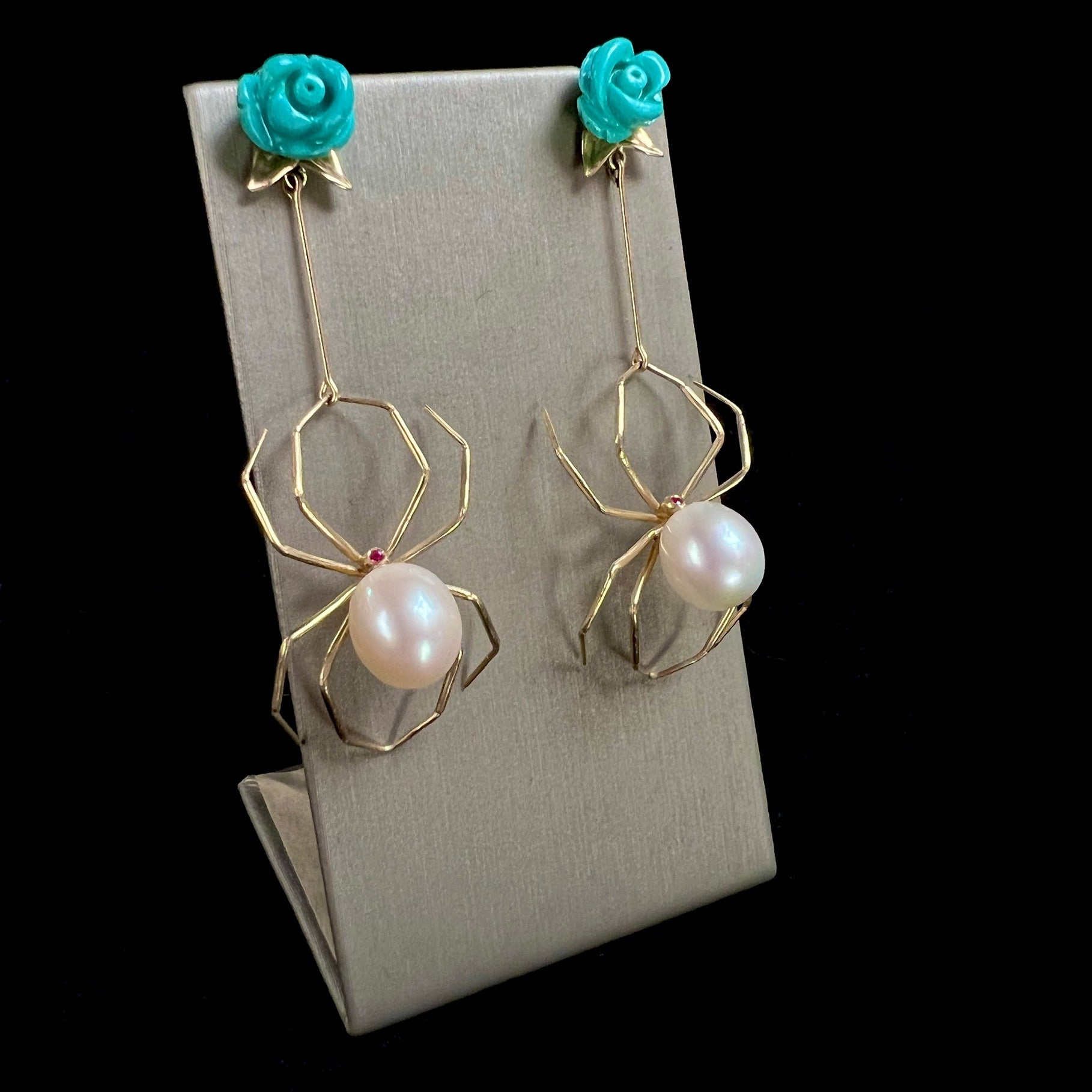 Front view of Turquoise and Pearl Spider Earrings on display stand
