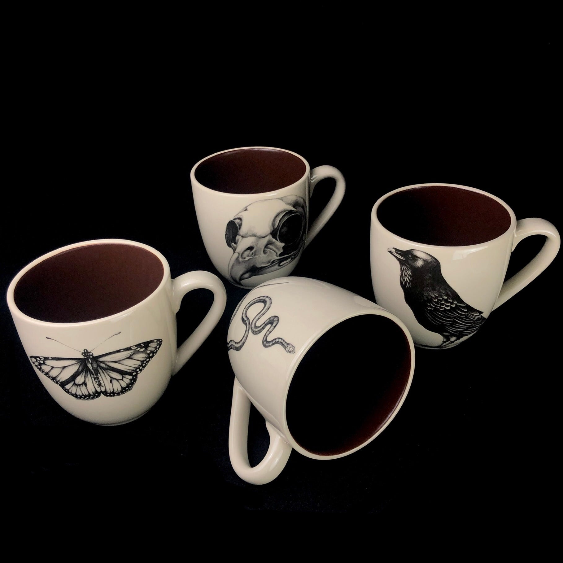 Set of four mugs referencing death including the Monarch Butterfly, Snake, Raven and Owl Skull