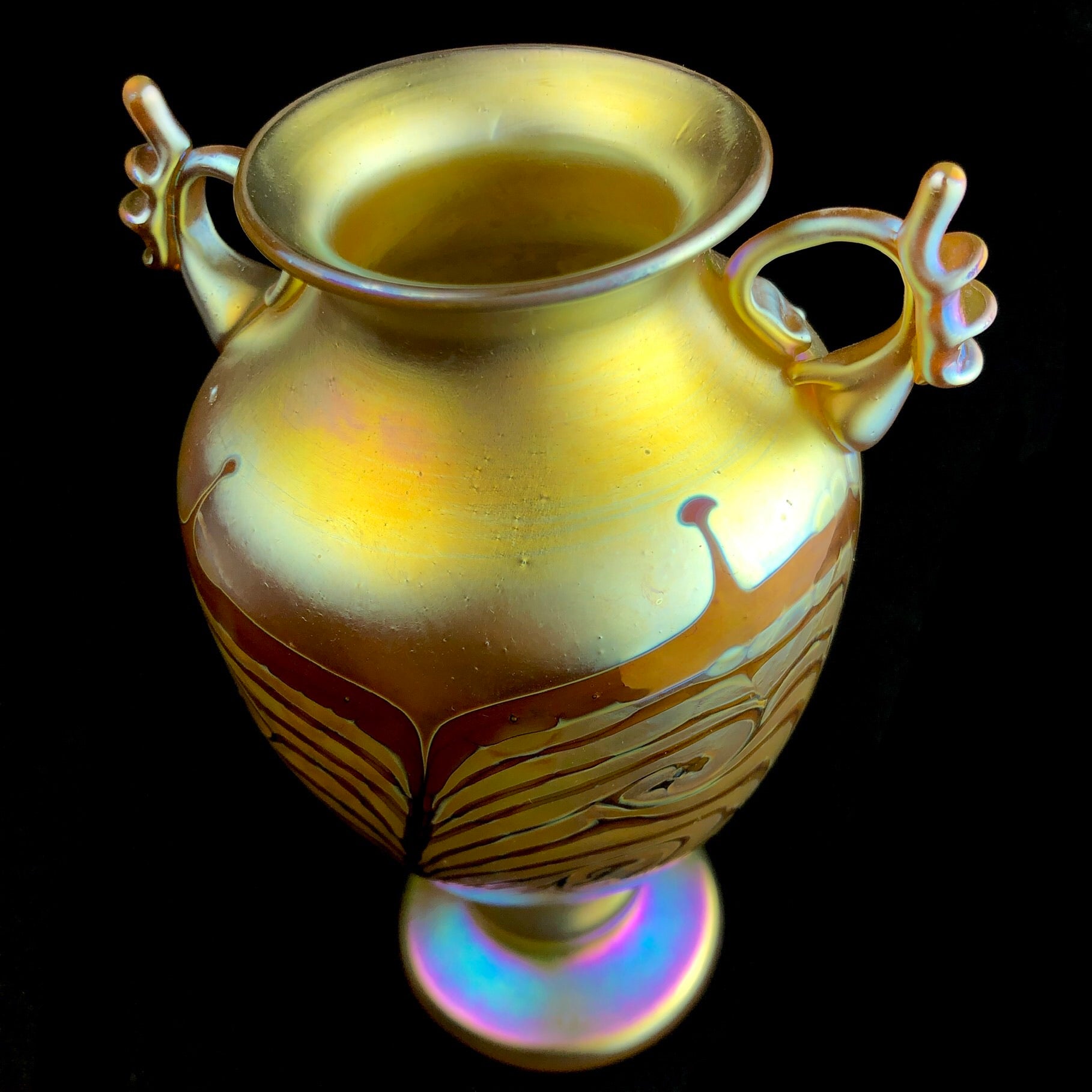 Top view of iridescent yellow glass vase with handle detail
