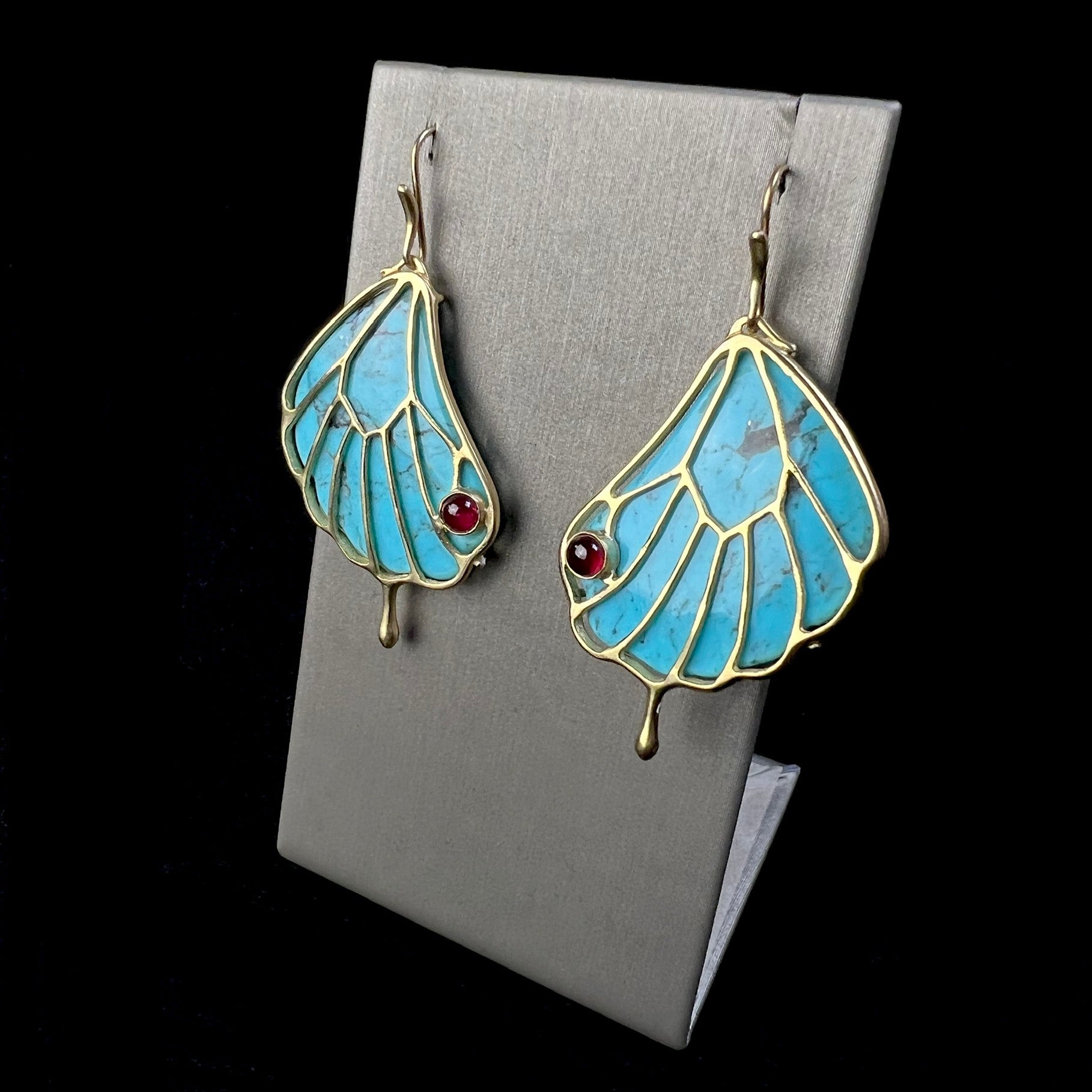 Front view of Turquoise Papillon Wing Earrings on display stand.